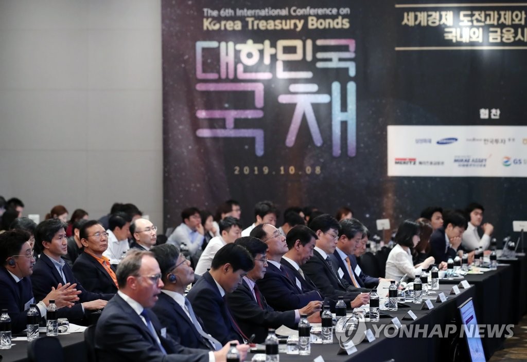 South Korean Finance Minister Hong Nam-ki (5th from L, front row) and other participants listen to comments by panelists at an international conference on Korea Treasury bonds at the Conrad Hotel in western Seoul on Oct. 8, 2019. (Yonhap)