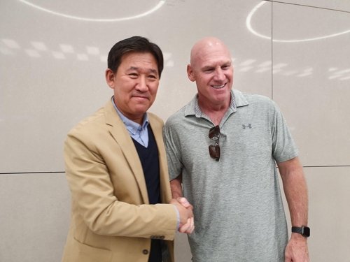 Matt Williams (R), new manager of the Kia Tigers in the Korea Baseball Organization, shakes hands with his general manager, Cho Kye-hyun, after arriving at Incheon International Airport on Oct. 17, 2019. (Yonhap)