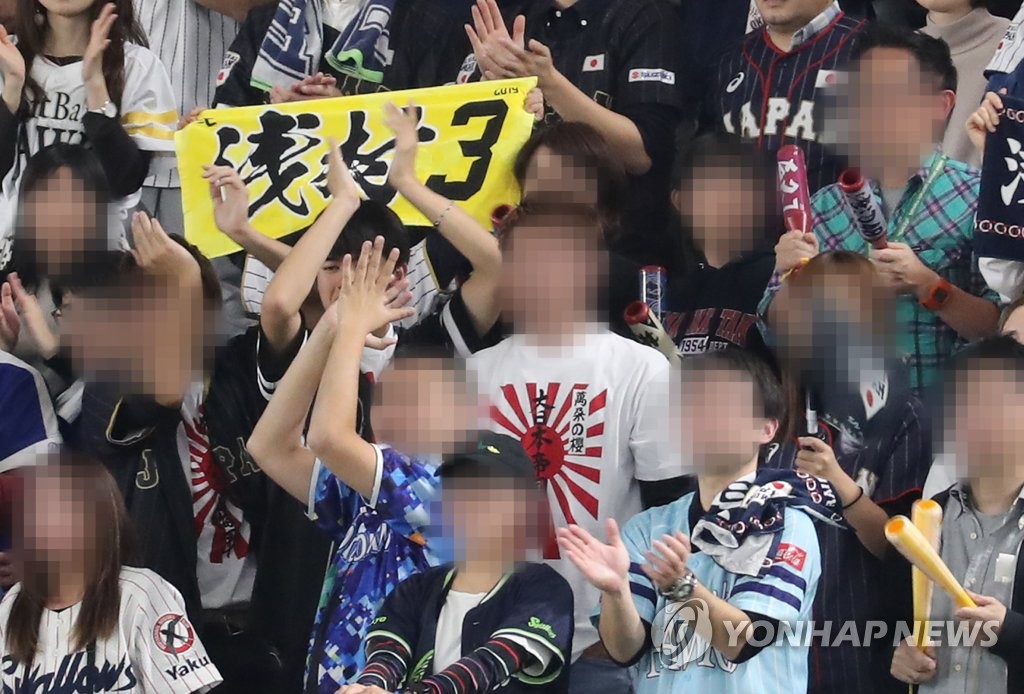 A Japanese fan wears a t-shirt bearing the image of the Rising Sun Flag during a game between South Korea and Japan in the Super Round of the World Baseball Softball Confederation (WBSC) Premier12 at Tokyo Dome in Tokyo on Nov. 16, 2019. (Yonhap)