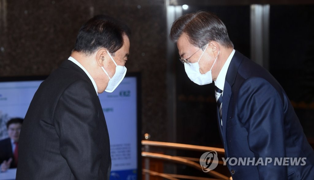 President Moon Jae-in (R) is greeted by National Assembly Speaker Moon Hee-sang, both wearing face masks, at the parliamentary building in western Seoul on Feb. 28, 2020. (Yonhap)