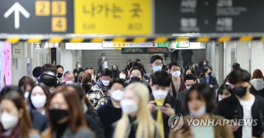 People wearing face masks walk through Sindorim metro station in Guro Ward, southwestern Seoul, during evening rush hour on March 10, 2020. The ward reported a large number of COVID-19 infections at an insurance firm call center on Monday. (Yonhap)
