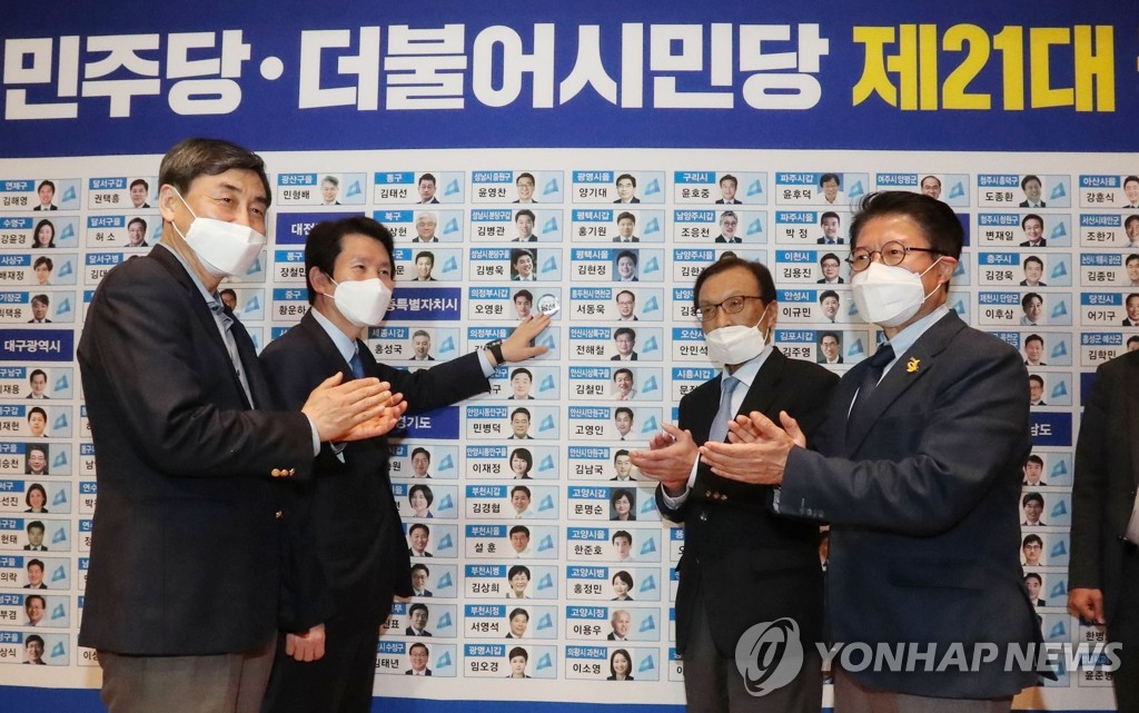 当選者にステッカーを貼る共に民主党の李海チャン代表（右から２人目）ら＝１５日、ソウル（聯合ニュース）