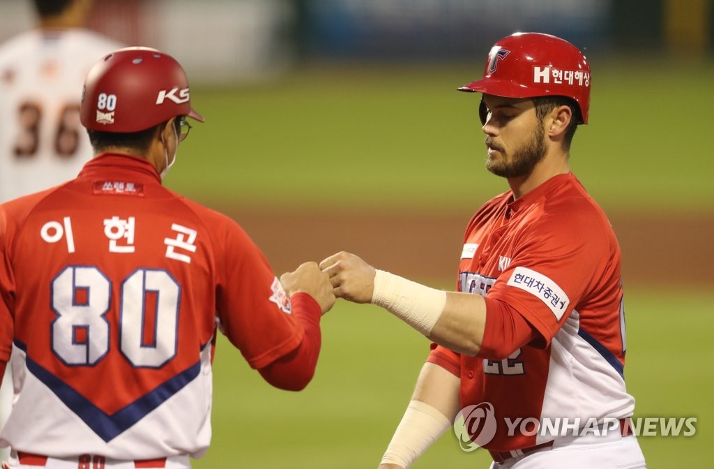 Preston Tucker of the Kia Tigers (R) bumps fists with first base coach Lee Hyun-gon after a single against the Hanwha Eagles during a Korea Baseball Organization regular season game at Hanwha Life Eagles Park in Daejeon, 160 kilometers south of Seoul, on May 14, 2020. (Yonhap)