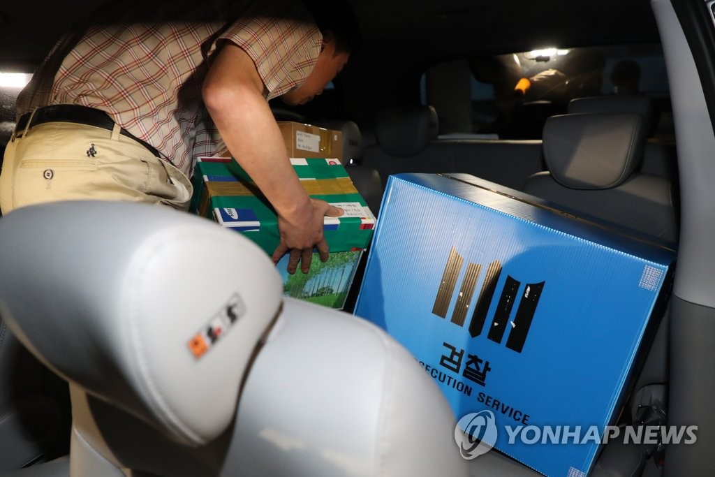 正義連からの押収品を車に運び込む検察＝２１日、ソウル（聯合ニュース）