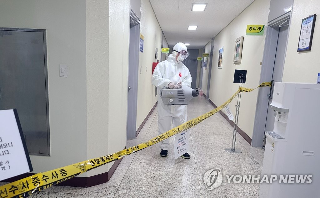 A worker disinfects a police station in Gwangju, 330 kilometers southwest of Seoul, on May 22, 2020, after a suspect under investigation showed symptoms of the new coronavirus, in this photo provided by a reader. (PHOTO NOT FOR SALE) (Yonhap)