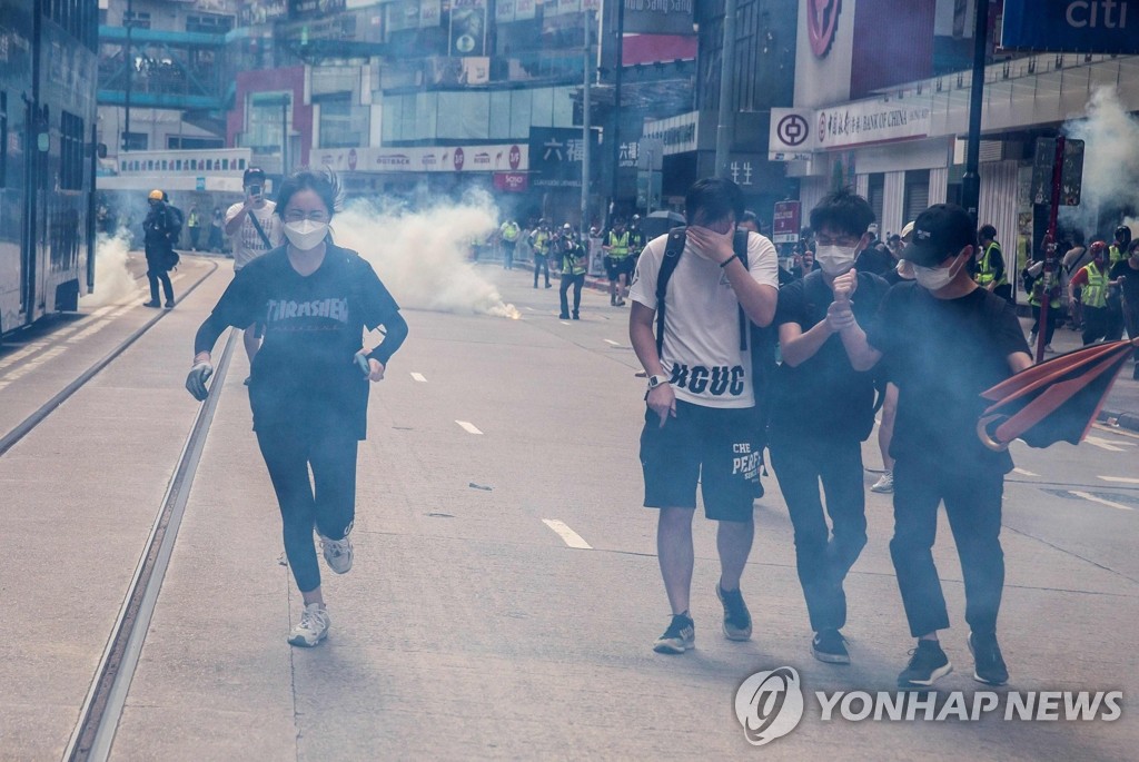 경찰 최루가스 발사에 피신하는 홍콩 시위대
