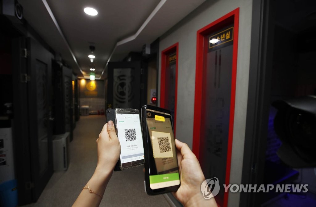 Local government officials check whether QR code-based logs are working at a karaoke establishment in Gwangju's Buk Ward, southwestern South Korea, on June 9, 2020, in this photo provided by the ward office. (PHOTO NOT FOR SALE) (Yonhap)