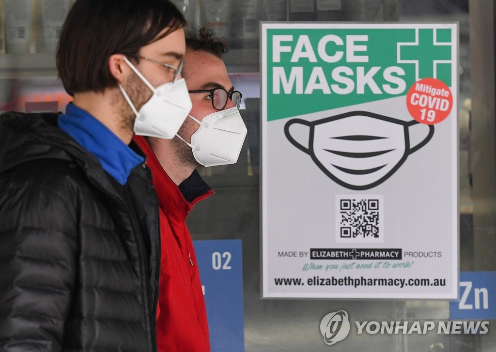 마스크 착용 의무화 호주 광고판 곁 지나는 시민들