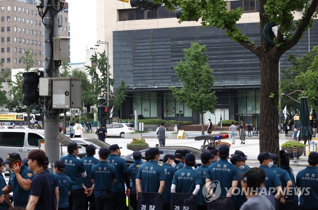 市中心部の光化門広場の向かいで待機する警察＝１２日、ソウル（聯合ニュース）