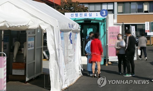 Visitors wait to receive new coronavirus tests at a makeshift clinic located in central Seoul on Oct. 20, 2020. (Yonhap)