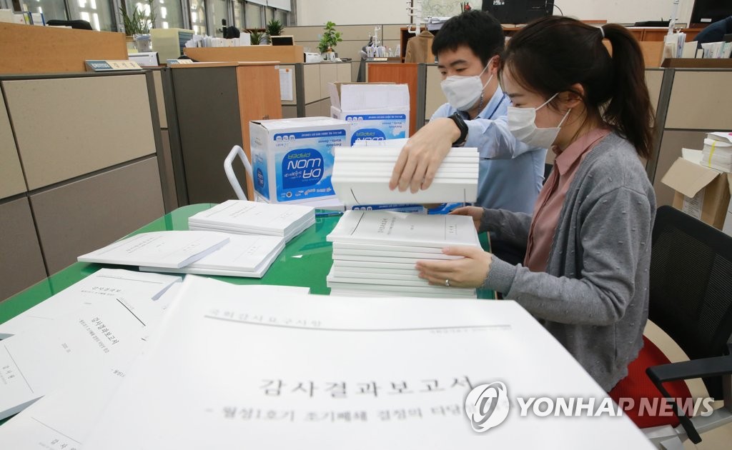 Employees at the National Assembly in central Seoul review an audit report on the early closure of the Wolsong-1 nuclear reactor disclosed by the Board of Audit and Inspection on Oct. 20, 2020. (Yonhap)