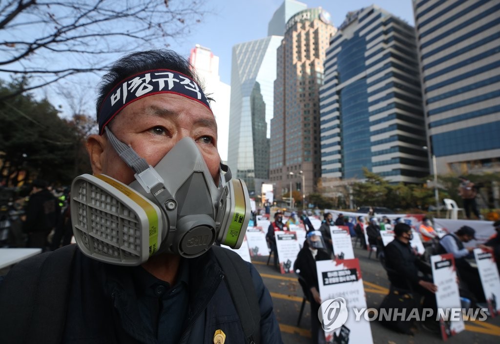A man wearing a gas mask participates in a rally organized by the Korean Confederation of Trade Unions in Yeouido, southern Seoul, on Nov. 14, 2020. (Yonhap)