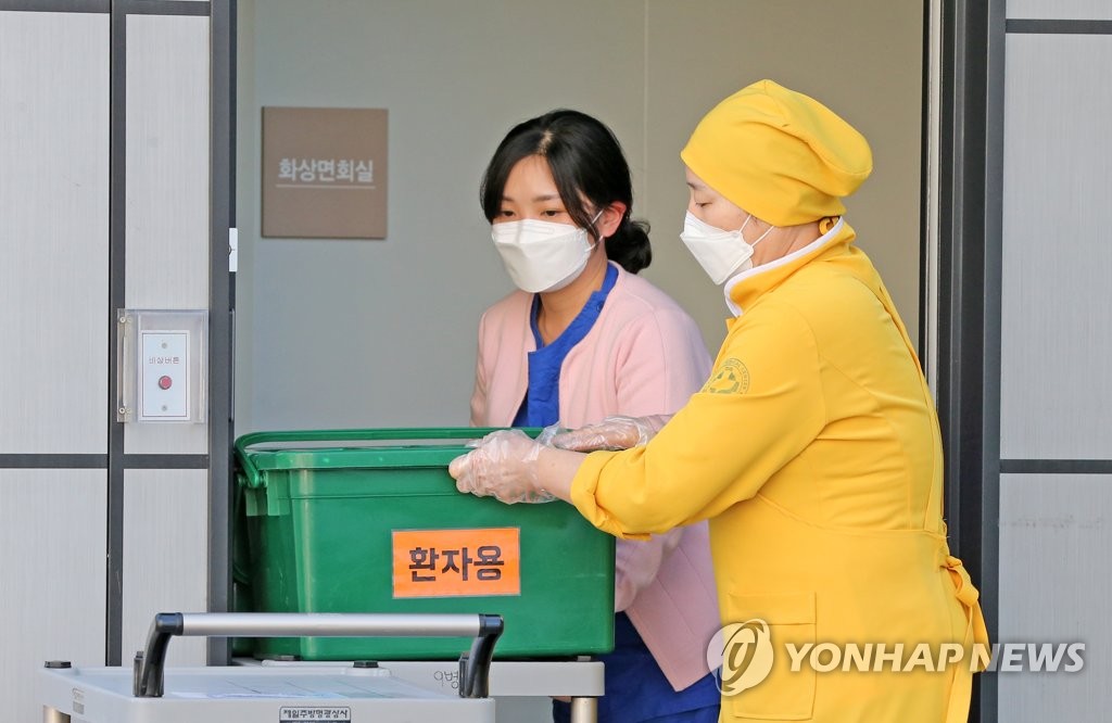 Health care workers deliver packed lunches to coronavirus-infected students taking the College Scholastic Ability Test at a medical facility in Pohang, 374 kilometers southeast of Seoul, on Dec. 3, 2020. (Yonhap)