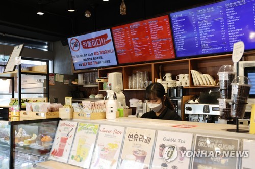 This file photo shows a sign criticizing the government's COVID-19 business restrictions at a cafe in southern Seoul on Jan. 6, 2021. (Yonhap)