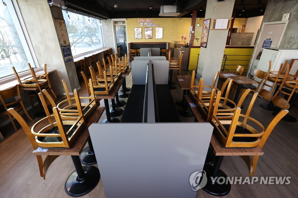 In this file photo, chairs are turned upside down on tables at a cafe in southern Seoul on Jan. 6, 2021, amid the government's COVID-19 restrictions on dining in at coffee shops. (Yonhap)