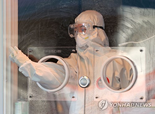 A medical worker cleans a temporary COVID-19 screening station set up in front of Seoul Station on Jan. 16, 2021. (Yonhap)