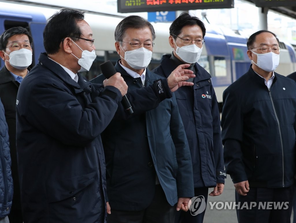 President Moon Jae-in (2nd from L) listens to Ulsan Mayor Song Cheol-ho (far L) as he attends a meeting at a train station in the southeastern port city of Busan on Feb. 25, 2021, about a set of strategies to develop the country's southeastern area. (Yonhap)