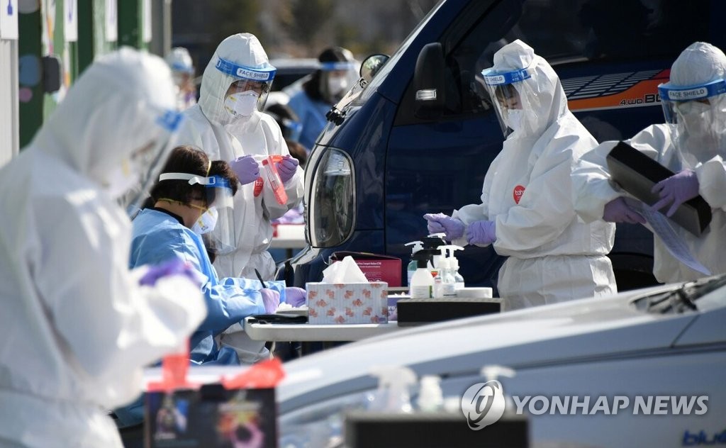 Health care workers conduct COVID-19 tests at a temporary testing station in Pyeongchang, 182 kilometers east of Seoul, on March 11, 2021, in this photo provided by Pyeongchang County. (PHOTO NOT FOR SALE) (Yonhap)