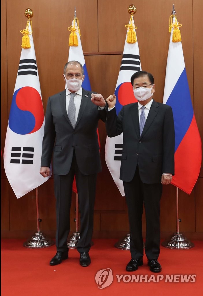 In this file photo, Foreign Minister Chung Eui-yong (R) and his Russian counterpart, Sergey Lavrov, fist bump at the foreign ministry office in central Seoul during the Russian diplomat's visit to South Korea on March 25, 2021. (Pool photo) (Yonhap)