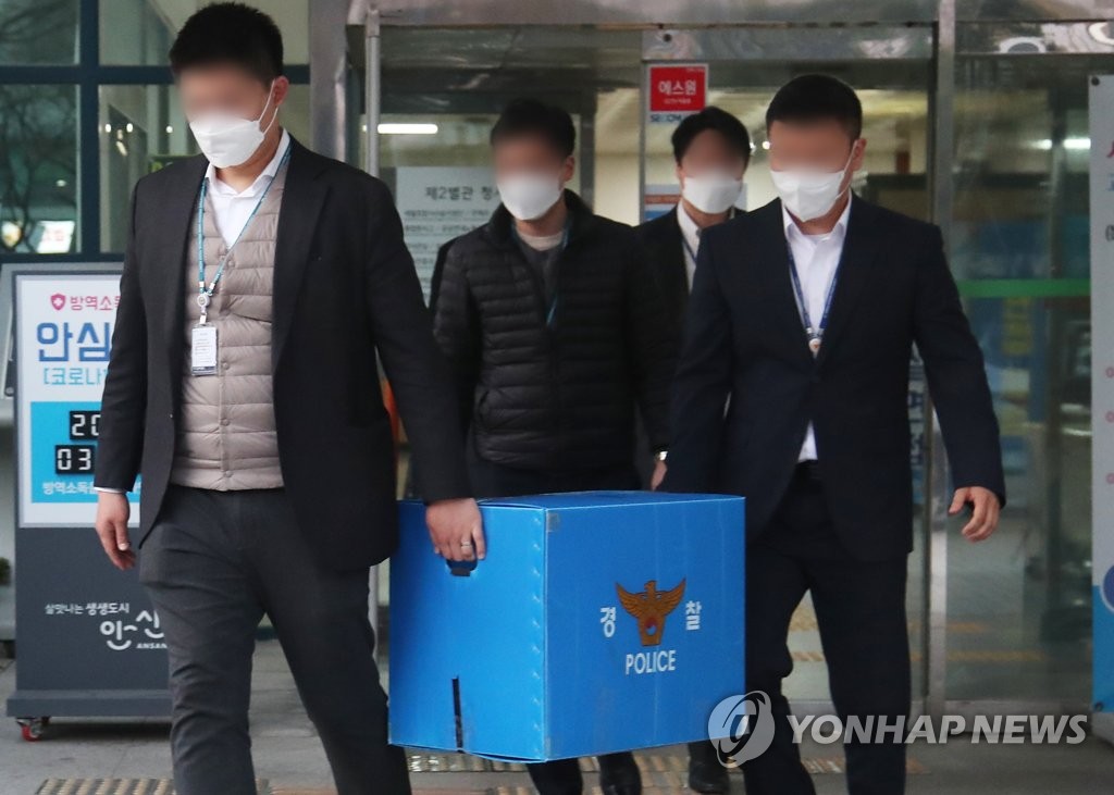 Police officers move a box of items they seized during a search of the city hall of Ansan, south of Seoul, on March 29, 2021, as part of investigation into a suspicious land purchase by the wife of a former aide to Interior Minister Jeon Hae-cheol. (Yonhap)