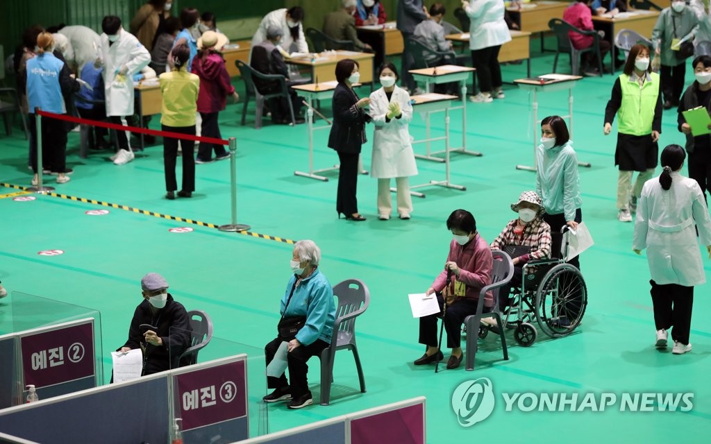 Senior citizens wait in line to see doctors before getting vaccinated at a gymnasium in Gwangju on April 19, 2021. (Yonhap)