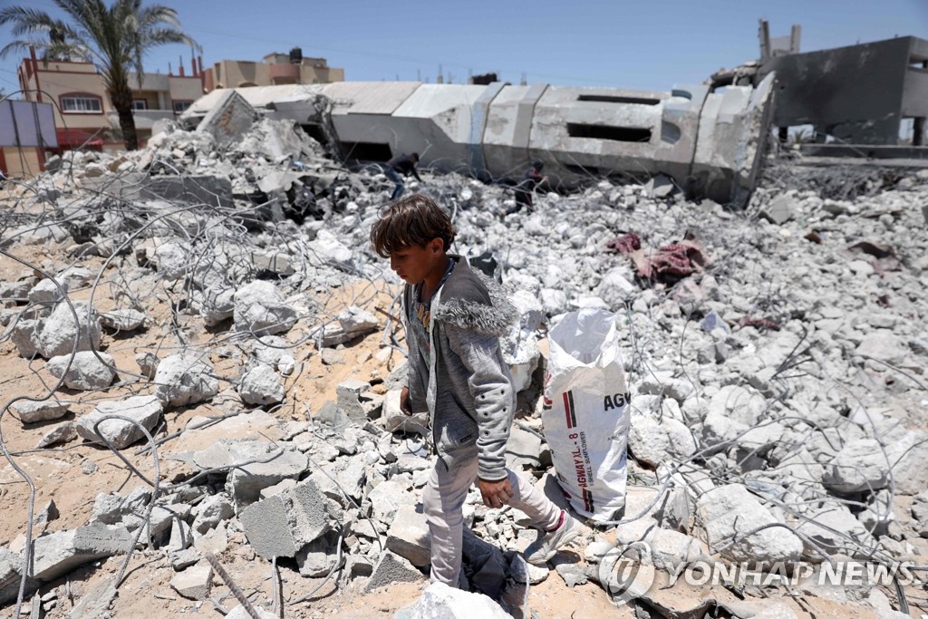 붕괴한 이슬람 사원 잔해 줍는 팔레스타인 어린이