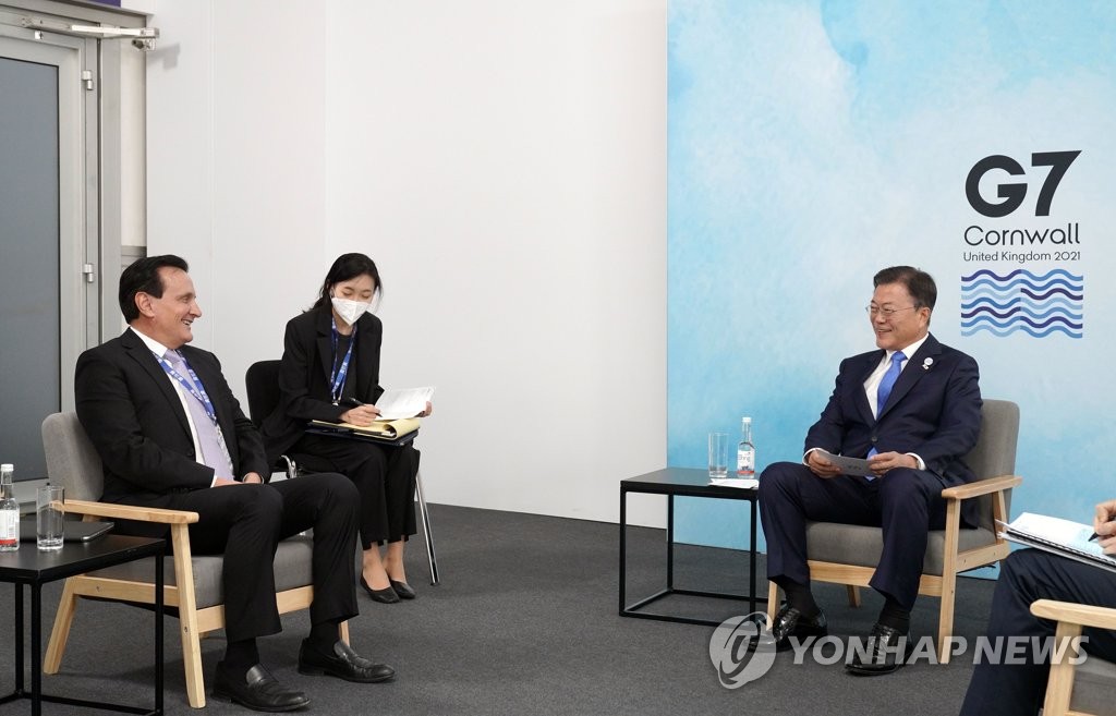 South Korean President Moon Jae-in (R) talks with Pascal Soriot, CEO of AstraZeneca, in the British county of Cornwall on June 12, 2021. (Yonhap)