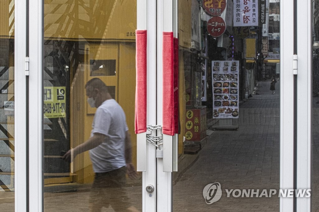 서울 중구 명동에서 텅 빈 거리가 문 닫은 상점의 유리문에 투영되고 있는 모습. [연합뉴스 자료사진]