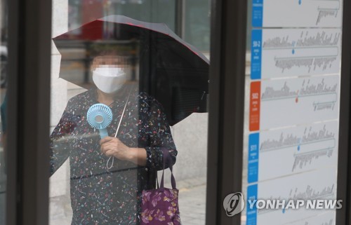 폭염 속 양산과 손 선풍기