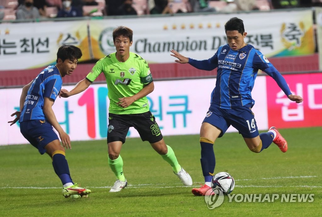 Lee Dong-gyeong of Ulsan Hyundai FC (R) takes a shot against Jeonbuk Hyundai Motors during the clubs' K League 1 match at Jeonju World Cup Stadium in Jeonju, some 240 kilometers south of Seoul, on Nov. 6, 2021. (Yonhap)