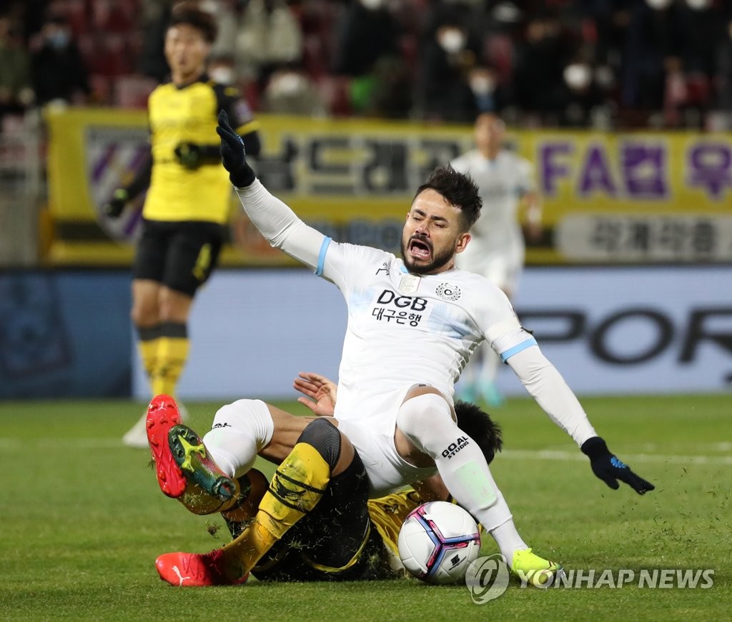 Cesinha of Daegu FC (top) is fouled by Kim Tae-hyun of Jeonnam Dragons during the opening leg of the FA Cup final at Gwangyang Football Stadium in Gwangyang, South Jeolla Province, on Nov. 24, 2021. (Yonhap)