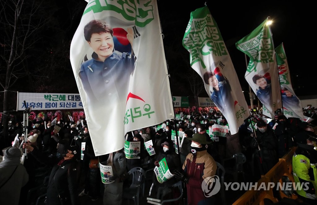 Supporters of former President Park Geun-hye celebrate in front of Samsung Medical Center in the early hours of Dec. 31, 2021, as she was set free under a presidential pardon at midnight after four years and nine months of imprisonment following her impeachment and ouster from office for corruption in March 2017. Park has been treated at the clinic since Nov. 22 due to chronic shoulder and lower back pain and other ailments. (Pool photo) (Yonhap)