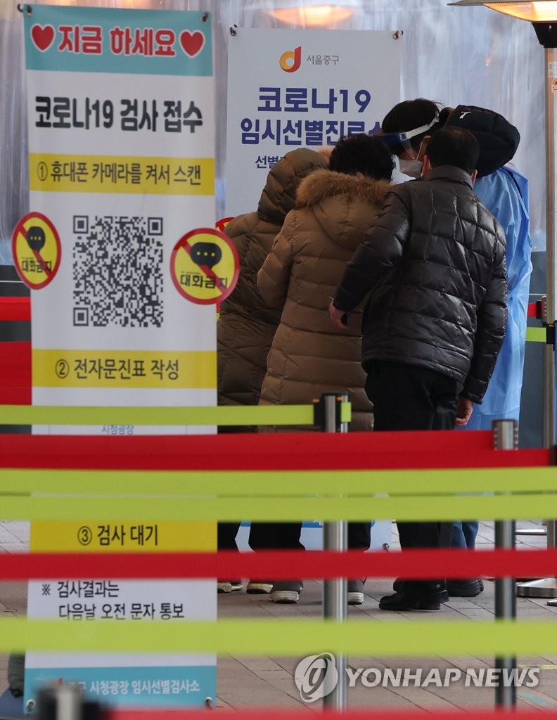A medical worker guides people standing in line to take coronavirus tests at a screening clinic in front of Seoul City Hall on Jan. 5, 2022. South Korea's daily coronavirus cases bounced back to above 4,000 for the first time in three days, putting health authorities on high alert over a possible resurgence amid omicron concerns. (Yonhap)