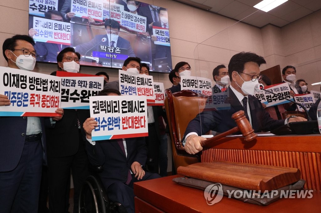 Lawmakers of the main opposition People Power Party (standing) stage a protest as the ruling Democratic Party attempts to pass controversial bills on prosecution reform during a session of the parliamentary legislation and judiciary committee at the National Assembly in Seoul on April 26, 2022. (Pool photo) (Yonhap)