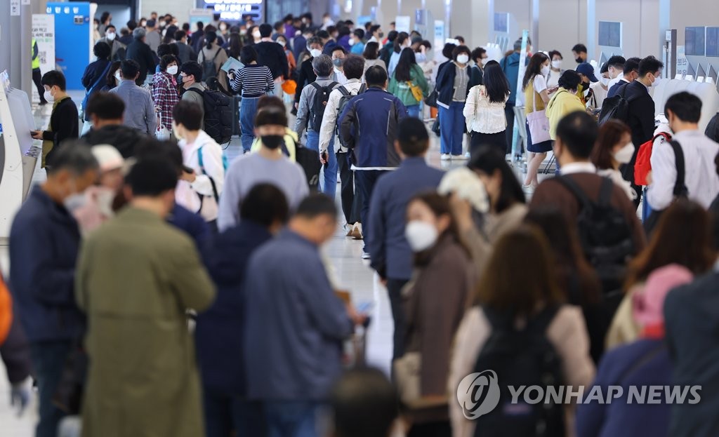Gimpo International Airport in Seoul is crowded with people wearing masks on April 29, 2022. (Yonhap)