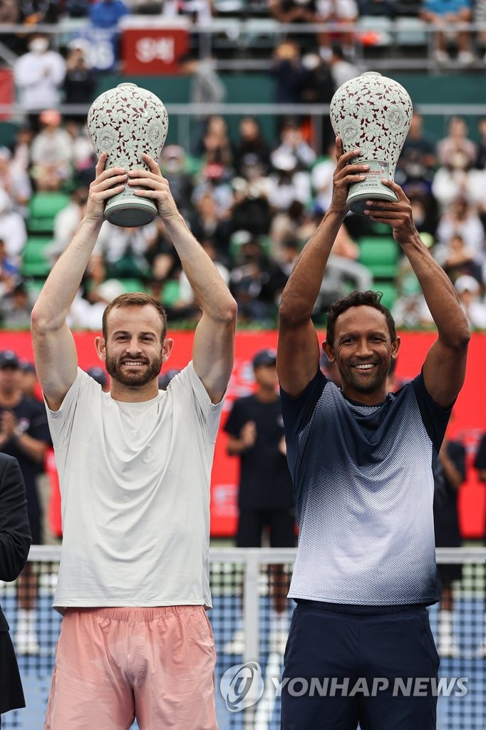 Nathaniel Lammons of the United States (L) and Raven Klaasen of South Africa hoist their trophies after winning the men's doubles title at the ATP Eugene Korea Open at Olympic Park Tennis Center in Seoul on Oct. 2, 2022. (Yonhap)