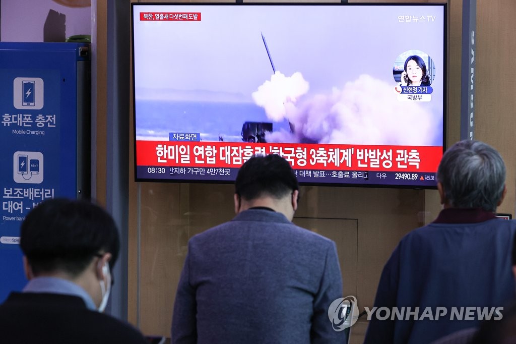 People watch a TV report at Seoul Station on Oct. 4, 2022, on North Korea's firing of an intermediate range ballistic missile (IRBM) into the Pacific Ocean past Japan earlier in the day. (Yonhap)