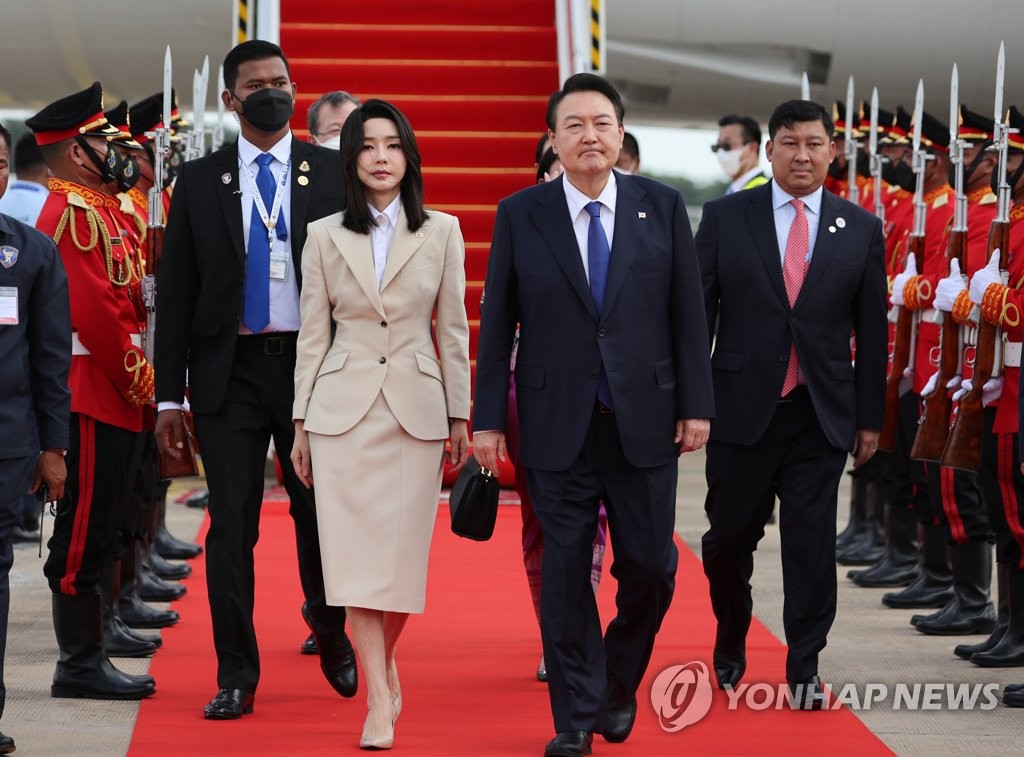El presidente surcoreano, Yoon Suk-yeol (dcha.), y la primera dama, Kim Keon-hee, llegan, el 11 de noviembre de 2022, al Aeropuerto Internacional de Nom Pen, en la capital camboyana.