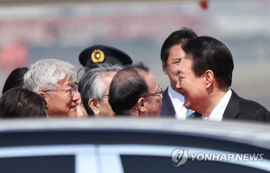 El presidente surcoreano, Yoon Suk Yeol (dcha.), recibe la bienvenida del embajador de Corea del Sur ante Japón, Yun Duk-min (izda.), tras su llegada al Aeropuerto Internacional de Haneda, en Tokio, el 16 de marzo de 2023, para sostener una cumbre con el primer ministro japonés, Fumio Kishida.