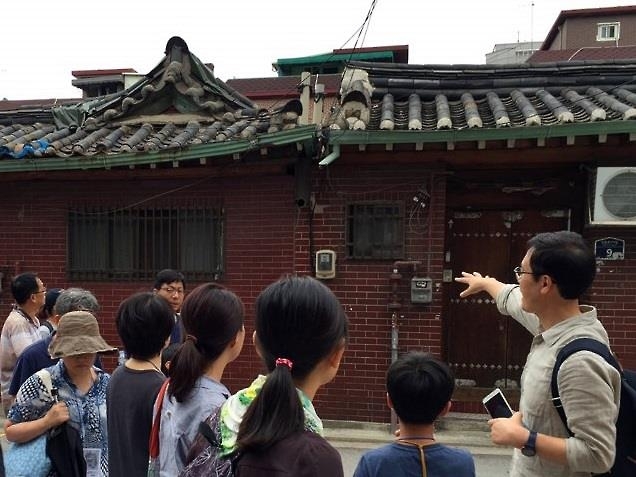 Professor Kim Young-soo at the Institute of Seoul Studies under University of Seoul (R) speaks during a guided tour to a hanok village in Seongbuk Ward, northeastern Seoul, on Sept. 4, 2016. The tour was the first in a four-part series of guided tours along the ancient fortress wall in the capital city. (Yonhap)