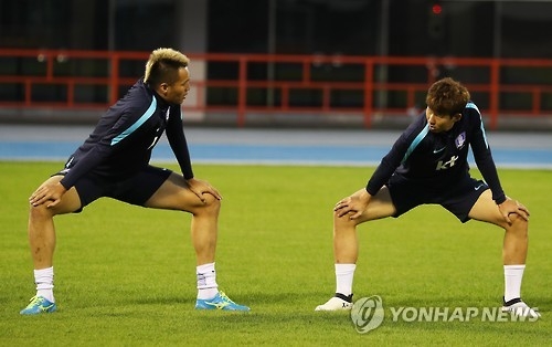 South Korean striker Kim Shin-wook (L) speaks with teammate Son Heung-min during the national team training session at Suwon Sports Complex in Suwon, south of Seoul, on Oct. 3, 2016. (Yonhap)