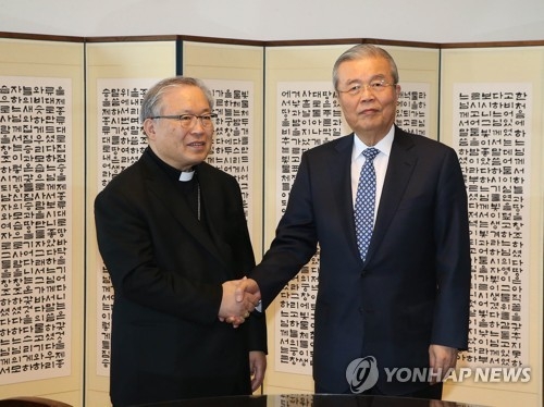 Kim Chong-in (R), former interim leader of the Democratic Party, shakes hands with Cardinal Andrew Yeom Soo-jung (L) on April 3, 2017, at the Myeongdong Cathedral in central Seoul. (Yonhap)