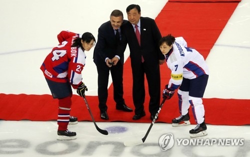 Rene Fasel (second from L), president of the International Ice Hockey Federation, and Lee Hee-beom (third from L), head of the 2018 PyeongChang Winter Olympics organizing committee, get ready for the ceremonial puck drop before the IIHF Women's World Championship Division II Group A game between South Korea and North Korea at Gangneung Hockey Centre in Gangneung, Gangwon Province, on April 6, 2017. In uniform are North Korean captain Kim Kum-bok (L) and South Korean captain Lee Kyou-sun. (Yonhap)