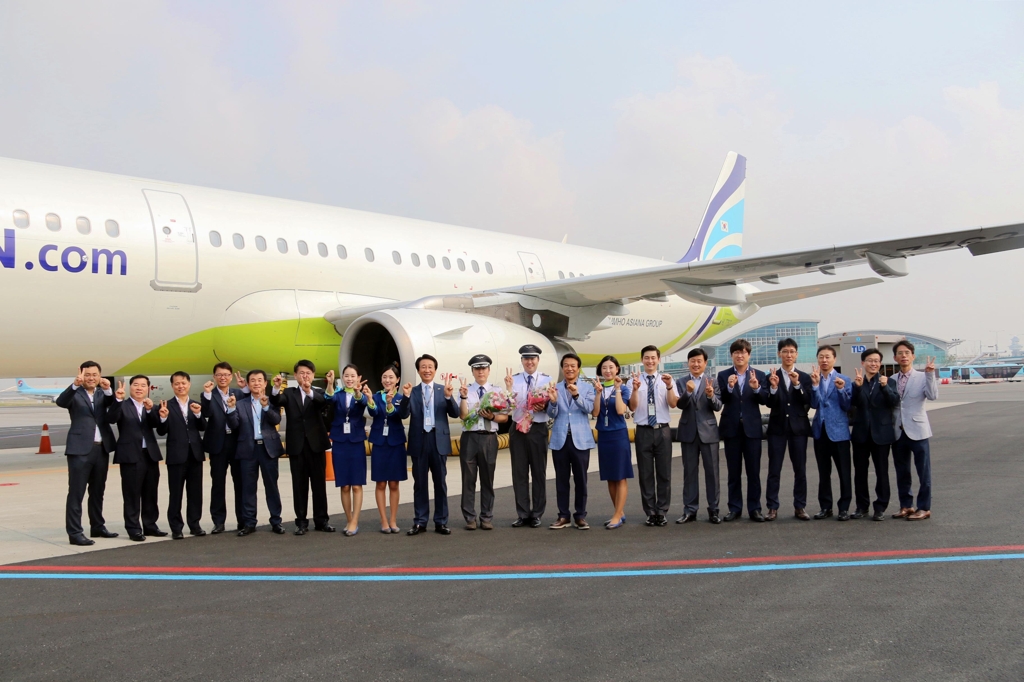 In this photo taken on June 1, 2017, and provided by Air Busan, Air Busan executives and employees stand before the company's 20th leased aircraft at Gimhae International Airport. (Yonhap)