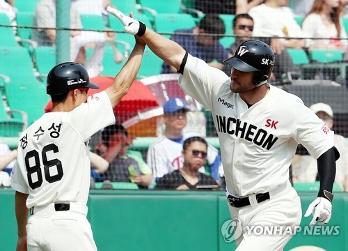 In this file photo taken on May 28, 2017, Jamie Romak of the SK Wyverns celebrates his home run with his third base coach Jung Soo-sung against the LG Twins during their Korea Baseball Organization regular season game at SK Happy Dream Park in Incheon. (Yonhap)