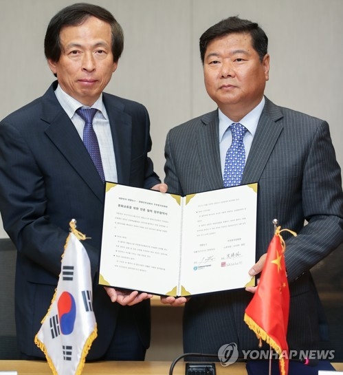 Lee Hong-ki (L), Yonhap News Agency's executive director, shakes hands with the director of the Chinese Cultural Center in Seoul on June 7, 2017. (Yonhap) 