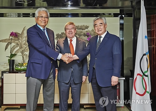 In this file photo provided by the World Taekwondo Federation (WTF) on Aug. 25, 2014, Chang Ung, then president of the International Taekwondo Federation (L) shakes hands with WTF President Choue Chung-won (R), with International Olympic Committee President Thomas Bach in the middle, in Nanjing, China, on the sidelines of the Youth Olympic Games in Nanjing, China. Chang and Chung signed "Protocol of Accord," an agreement detailing efforts to promote cooperation between the two organizations. (Yonhap)