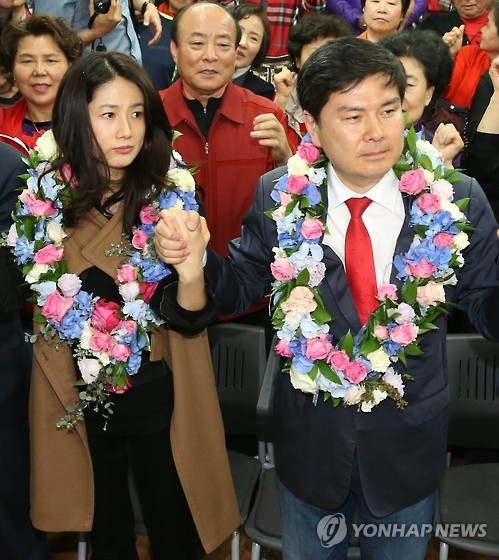 The file photo, taken on April 14, 2016, captures Shim Eun-ha (L), a retired actress, holding hands with her husband Ji Sang-wuk (R), then a candidate for the Saenuri Party, after he won his parliamentary seat in the general elections in Seoul. (Yonhap) 