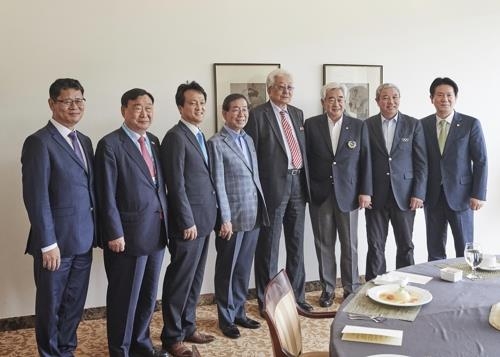 In this photo provided by the World Taekwondo Federation (WTF), attendees of the luncheon hosted by the WTF President Choue Chung-won (third from R) pose for pictures at the club house of Muju Deogyusan Country Club in Muju, North Jeolla Province. From left: Kim Yeon-chul, Inje University professor; Lee Hee-beom, head of the 2018 PyeongChang Winter Olympics organizing committee; An Min-seok, a Democratic Party legislator; Park Won-soon, mayor of Seoul; Chang Ung, North Korean member of the International Olympic Committee; Choue; Yu Zaiqing, an IOC vice president, and Lee Dong-sup, a People's Party lawmaker. (Yonhap)