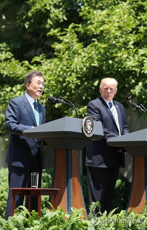South Korean President Moon Jae-in (L) and U.S. President Donald Trump hold a joint press conference following their bilateral summit at the White House on June 30, 2017. (Yonhap)